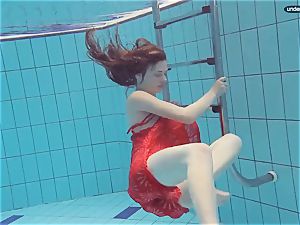 red clothed teen swimming with her eyes opened