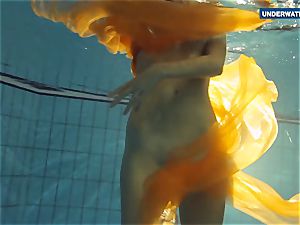Yellow and crimson clothed nubile underwater